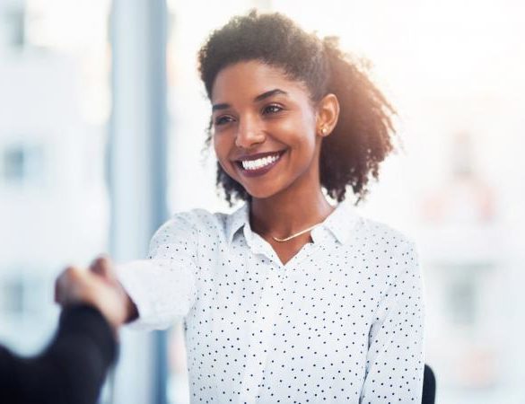 Young businesswoman shaking hands with a colleague in a modern office