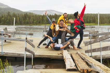 Heureux amis ludiques posant sur la jetée au bord d'un lac