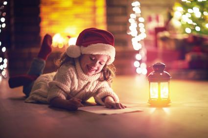 Enfant fille écrit lettre santa maison près de l'arbre de Noël