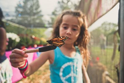 Fille Balance curieuse avec papillon monarque