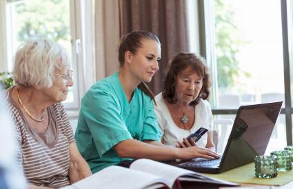 Infirmière avec des femmes âgées achetant des médicaments en ligne