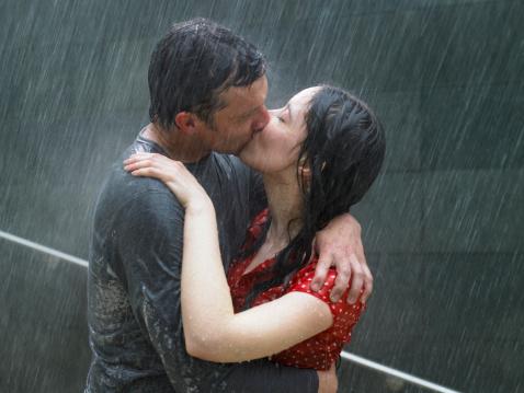 Couple s'embrassant sous la pluie