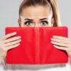 Woman covering face with book