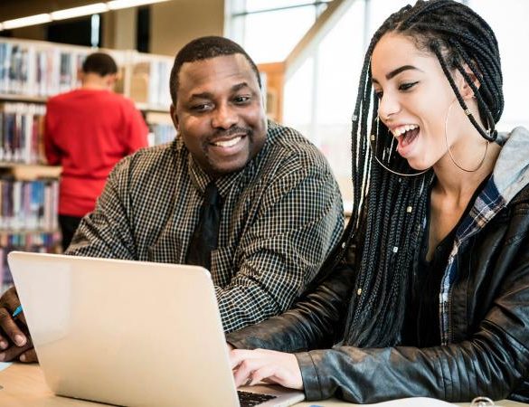 Teacher and student using laptop