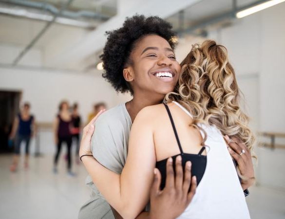 Dance instructor and student hugging