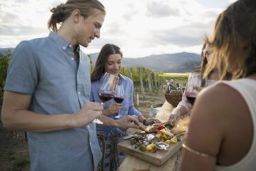 Friends enjoying wine tasting in vineyard