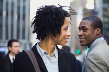 businesswoman making eye contact with man