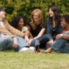Group of friends sitting on grass and laughing