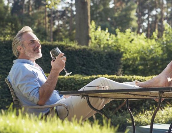 man in garden drinking wine