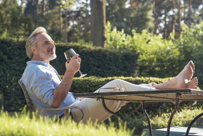 man in garden drinking wine