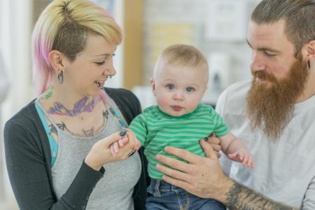 Parents alternatifs tenant bébé et souriant