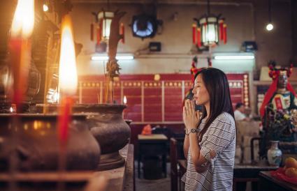 Femme priant dans un temple chinois