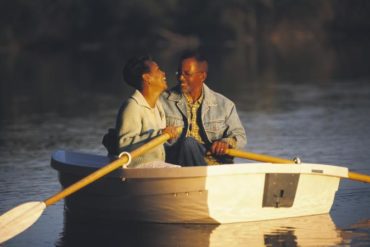 Woman laughing with man in rowboat