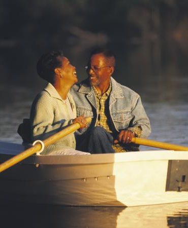 Woman laughing with man in rowboat