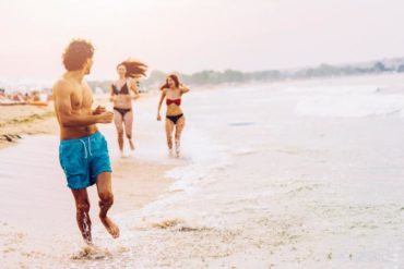 Women chasing a man on the beach