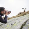 Man photographing goat