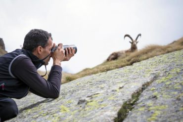 Man photographing goat