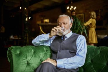 elegant senior man sitting on couch