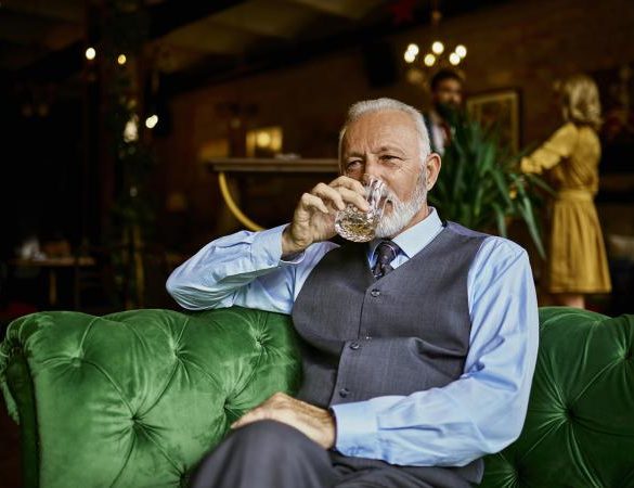 elegant senior man sitting on couch