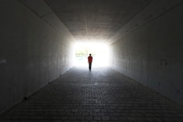 person walking out of a tunnel