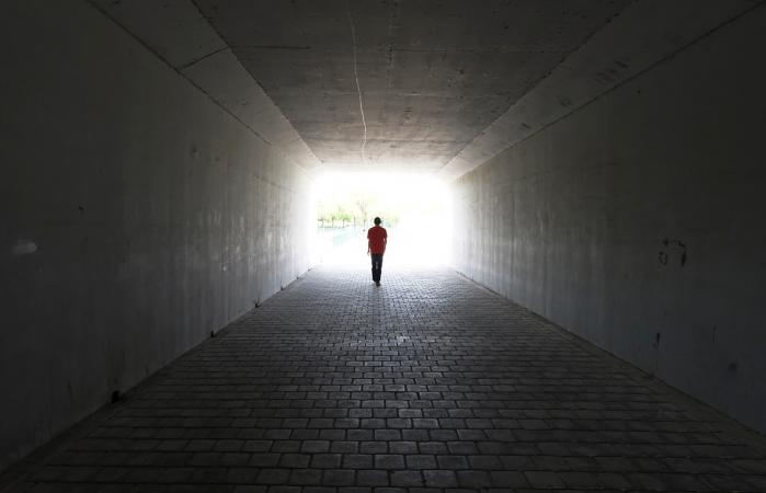 person walking out of a tunnel