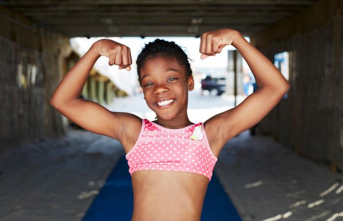 Girl flexing muscles outdoors