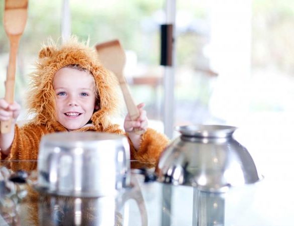 Boy dressed as a lion pretending to be drummer