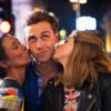 Flirty man kissed by two women