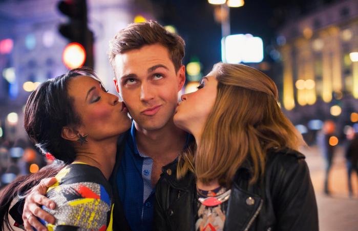 Flirty man kissed by two women