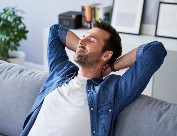 man sitting on sofa daydreaming
