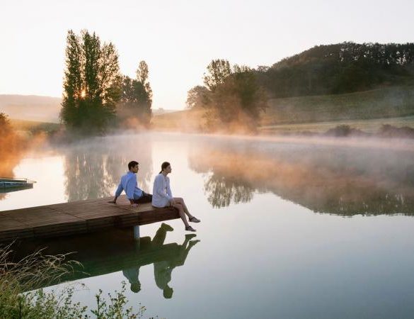 Couple relaxing on dock of lake