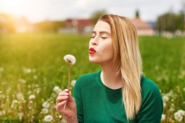 woman blowing daffodil