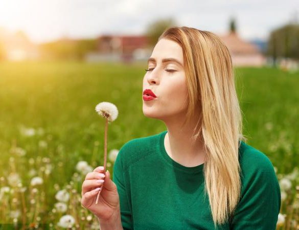 woman blowing daffodil