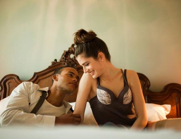 Couple sitting on double bed