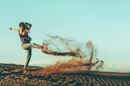 Jeune femme, coups de pied, sable, dans, paysage désertique