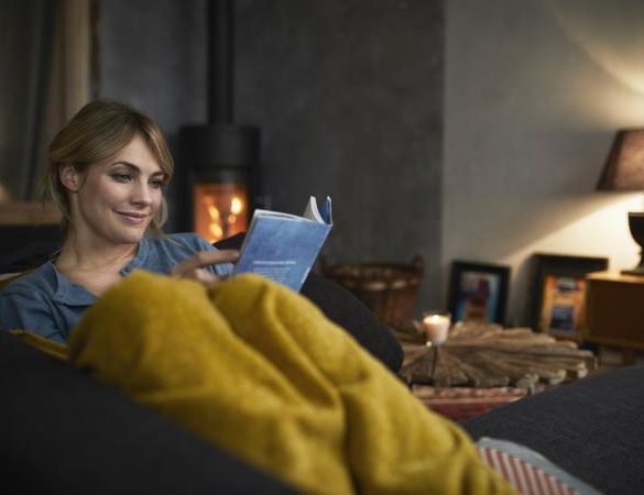 woman reading a book on couch