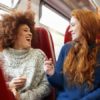Two women talking on a train