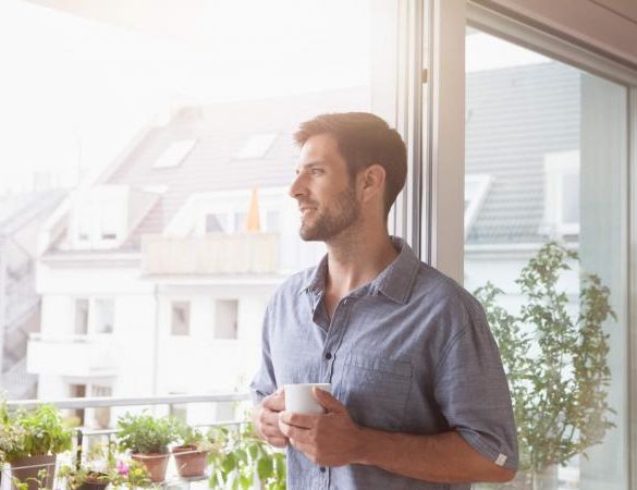Smiling man looking out of window