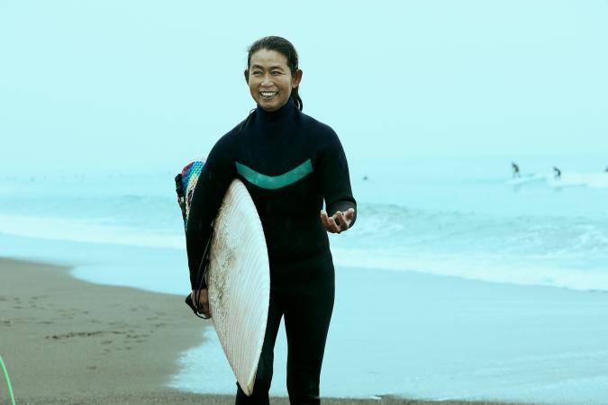 Femme sur la plage avec planche de surf